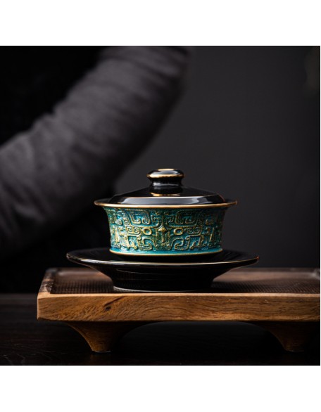 Masterfully handcrafted, hand-painted, gold-plated ceramic bowl with lid featuring a taotie design