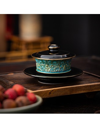 Masterfully handcrafted, hand-painted, gold-plated ceramic bowl with lid featuring a taotie design
